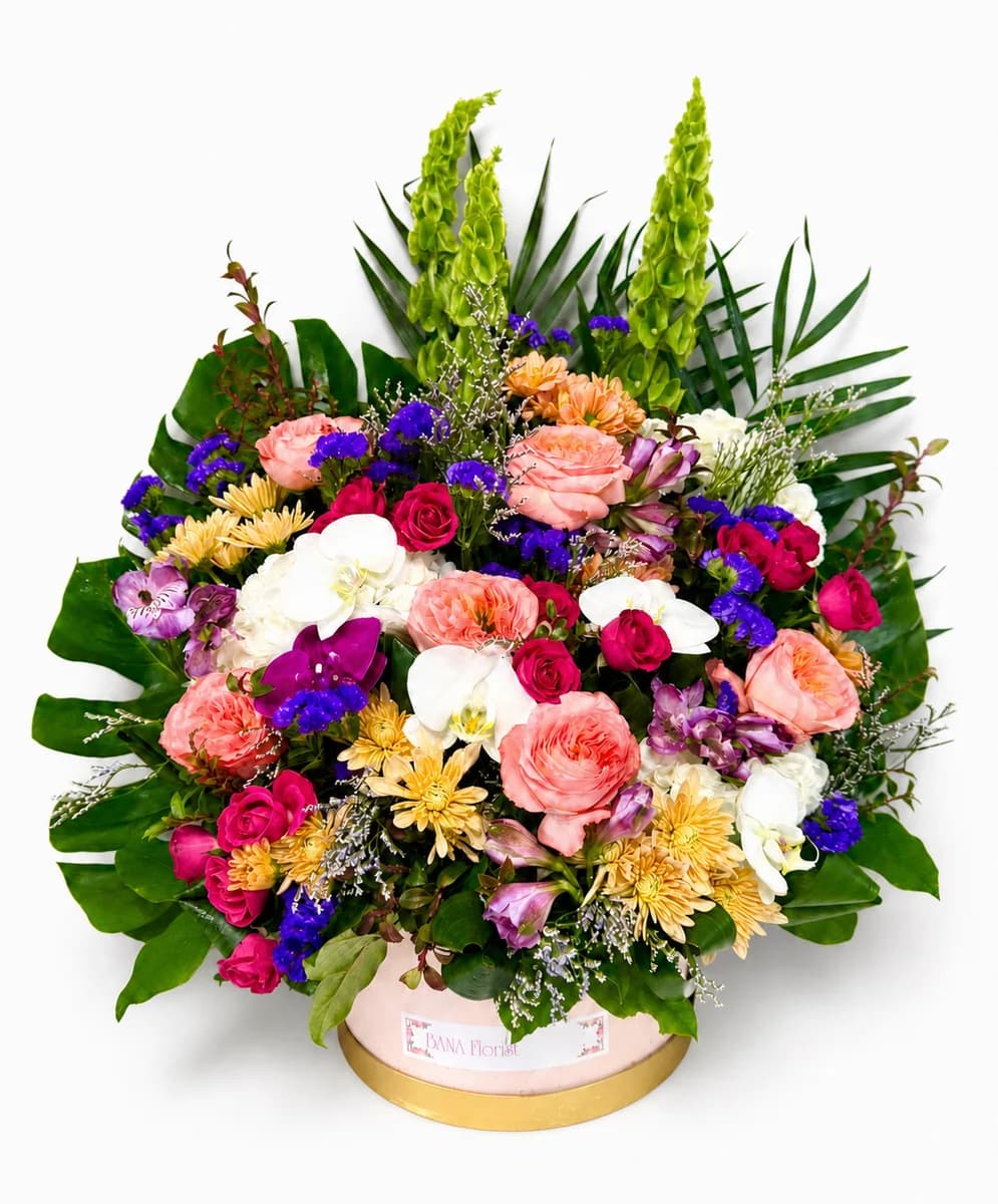 Mixed flower arrangement with garden roses and orchids in a blush and gold round box from Bana Florist Toronto