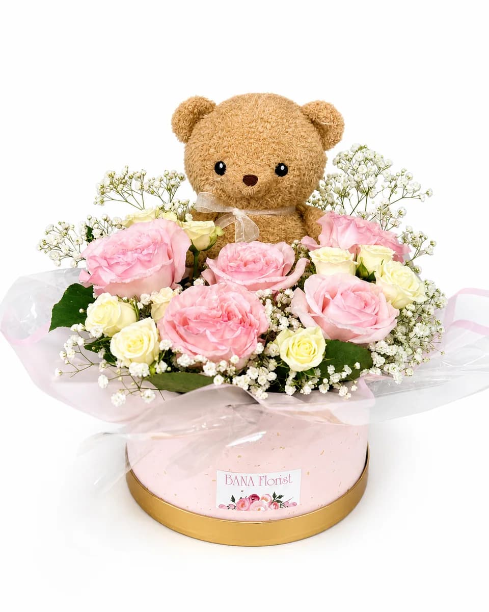 Pink and cream roses with a teddy bear in a pink round box from Bana Florist Toronto