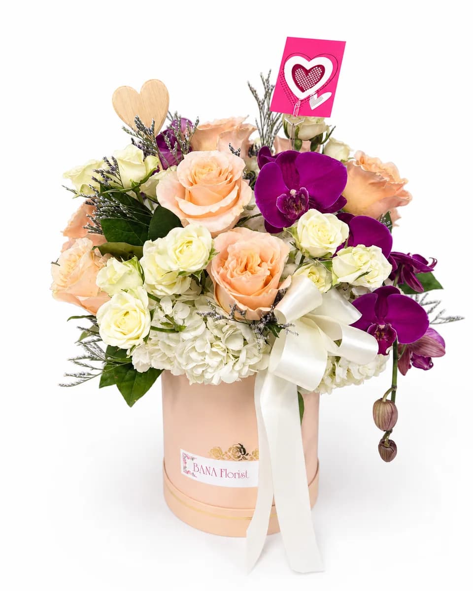 Peach roses, white hydrangea and purple orchids in a blush round box from Bana Florist Toronto