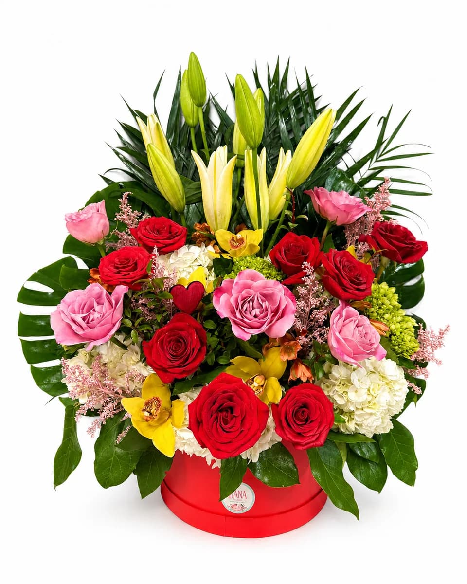 Red and pink roses with lilies and orchids in a red round box from Bana Florist Toronto